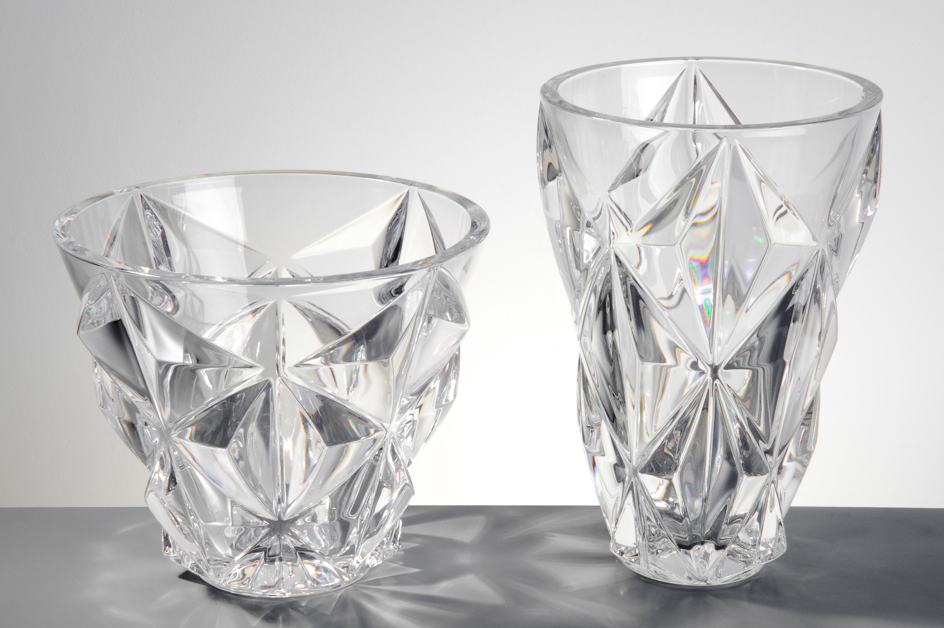 Pair of transparent glass vases with edges, isolated